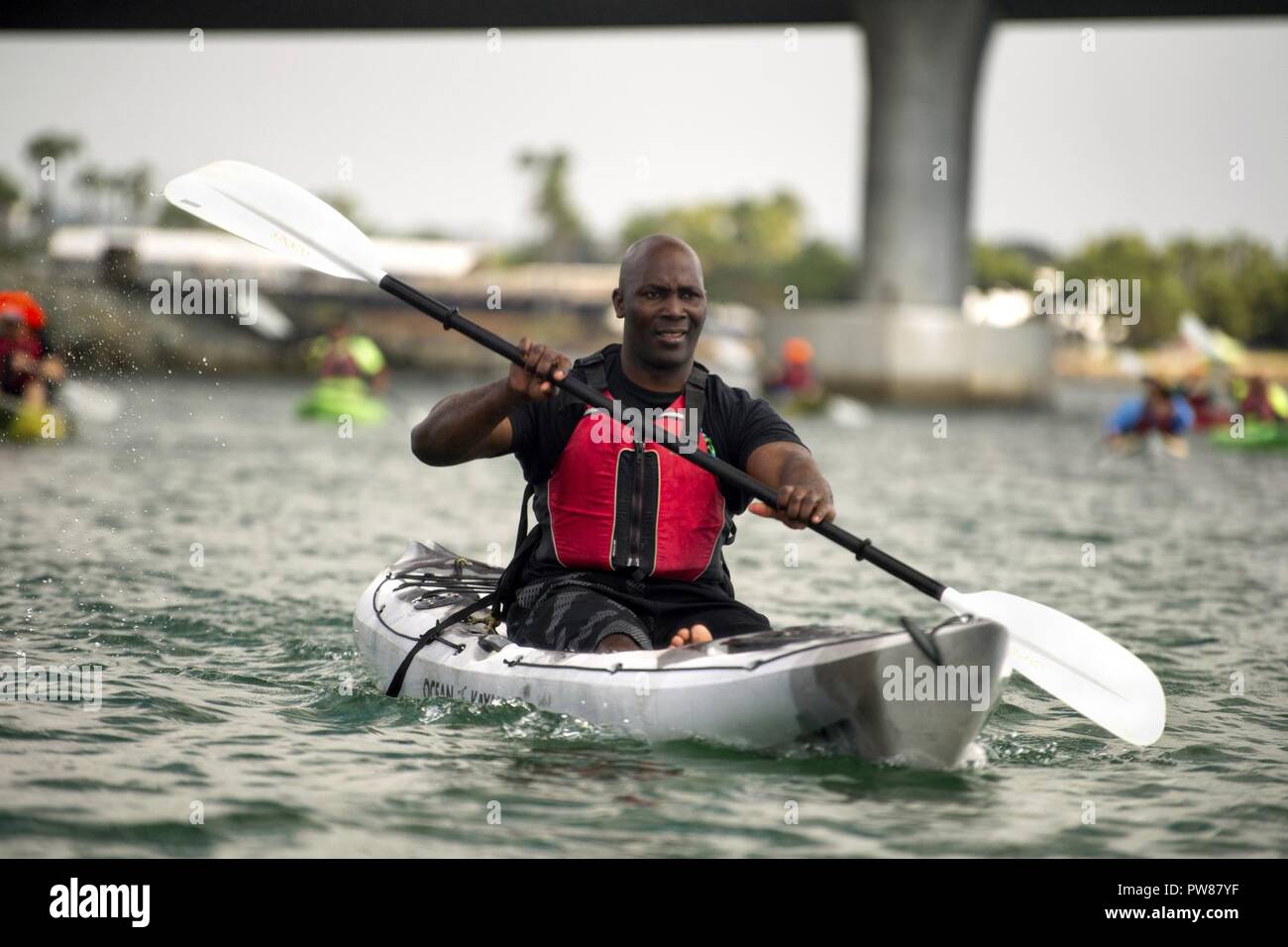 Navy Petty Officer 1st Class Michel Muller paddles a kayak in Mission Bay during an outing for Naval Medical Center San Diego patients in San Diego, Calif. Sept. 19, 2017. Stock Photo
