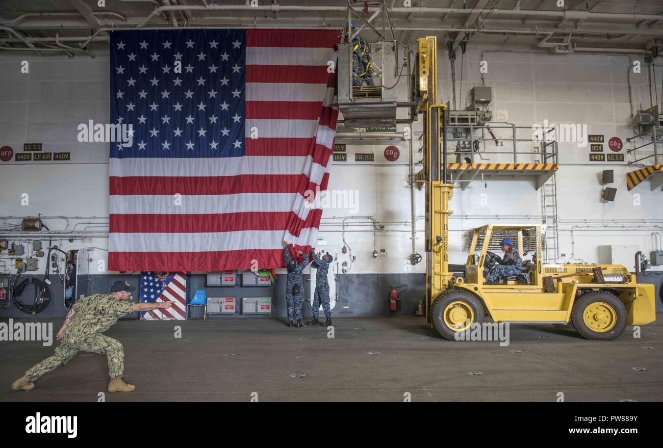 Norfolk Va Oct 3 17 Quartermaster 2nd Class Nicholas Delacruz Directs The Lift Driver Into Position So Sailors Can Hang The American Flag For A Change Of Command Ceremony Aboard The Aircraft