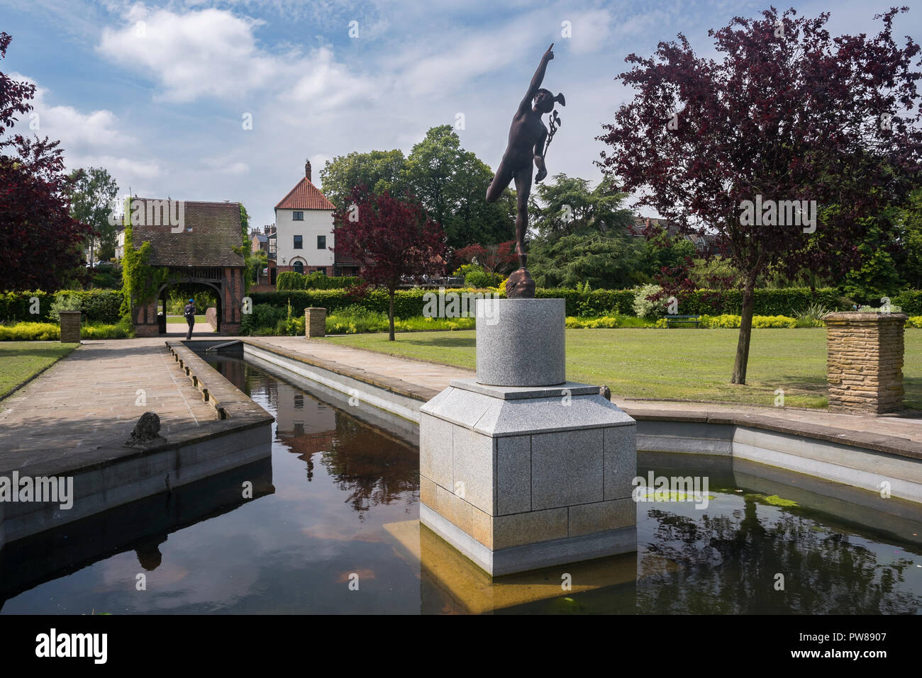 Sunny day view of water feature with statue & lych-gate dovecote, in beautiful peaceful, municipal gardens - Rowntree Memorial Park, York, England, UK Stock Photo