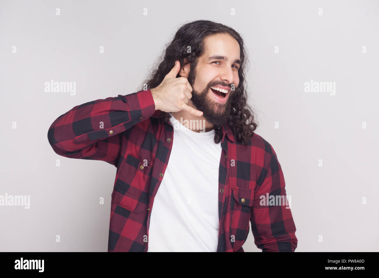Call me! funny man with beard and black long curly hair in casual style,  checkered red shirt standing, looking at camera with call gesture and  smiling Stock Photo - Alamy