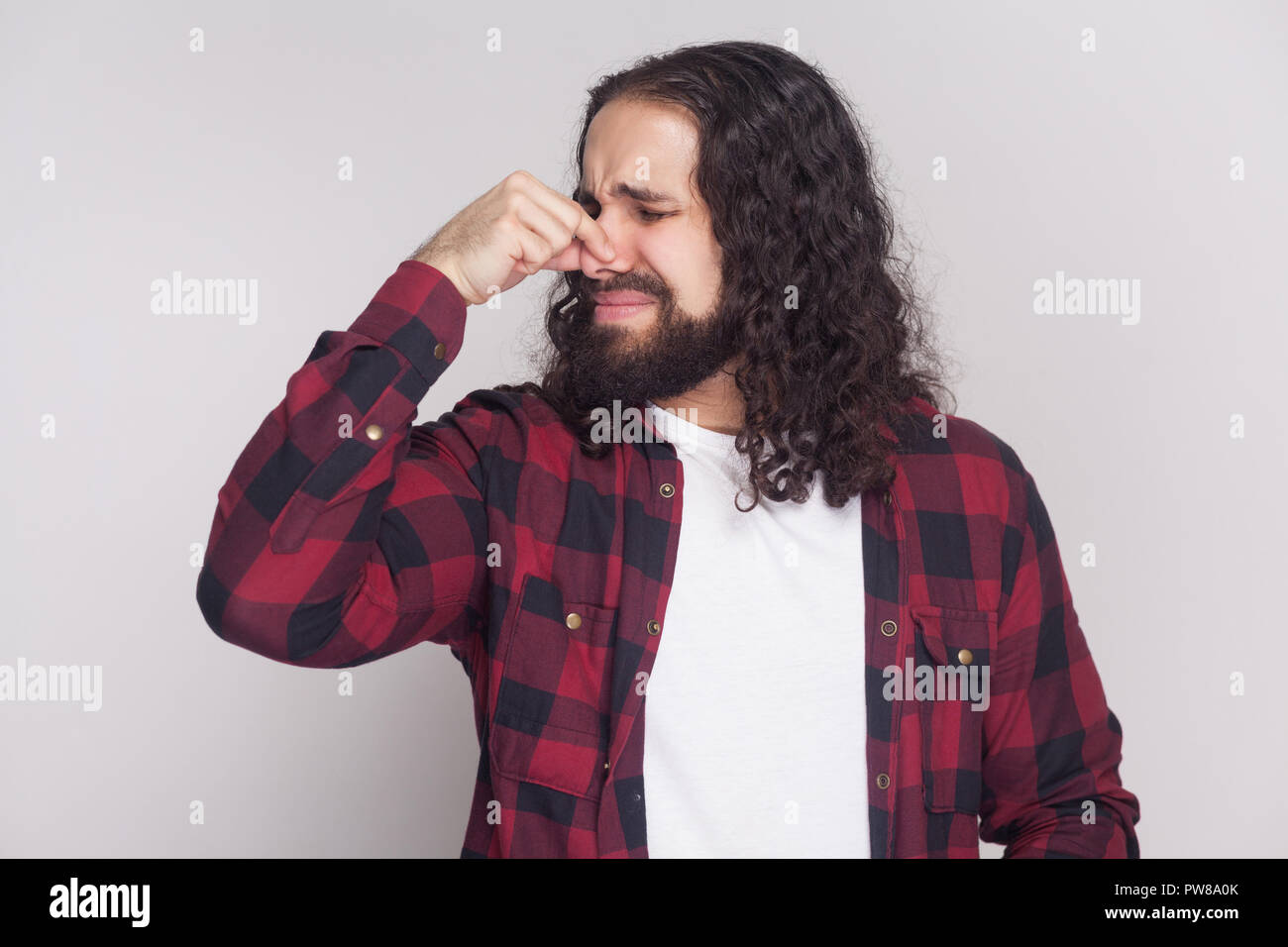 Bad smell. Squeamish man with beard and black long curly hair in casual style, checkered red shirt standing blocking his nose because bad smell. indoo Stock Photo - Alamy Bad smell. Squeamish man with beard and black long curly hair in casual style, checkered red shirt standing blocking his nose because bad smell. indoo Stock Photo - Alamy