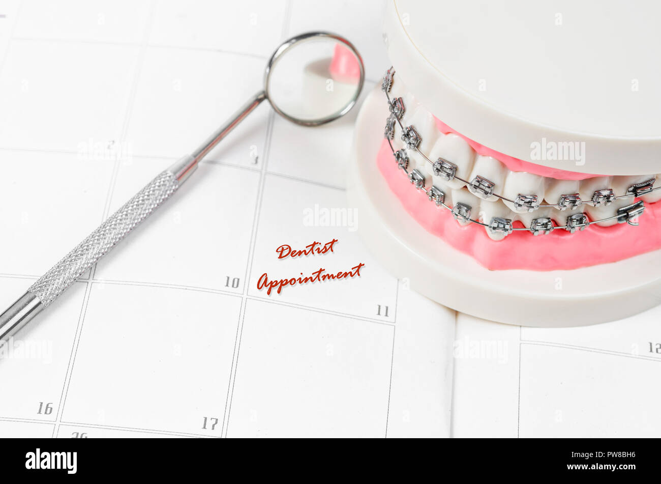 Tooth model with metal wire dental braces with dentist appointment on a