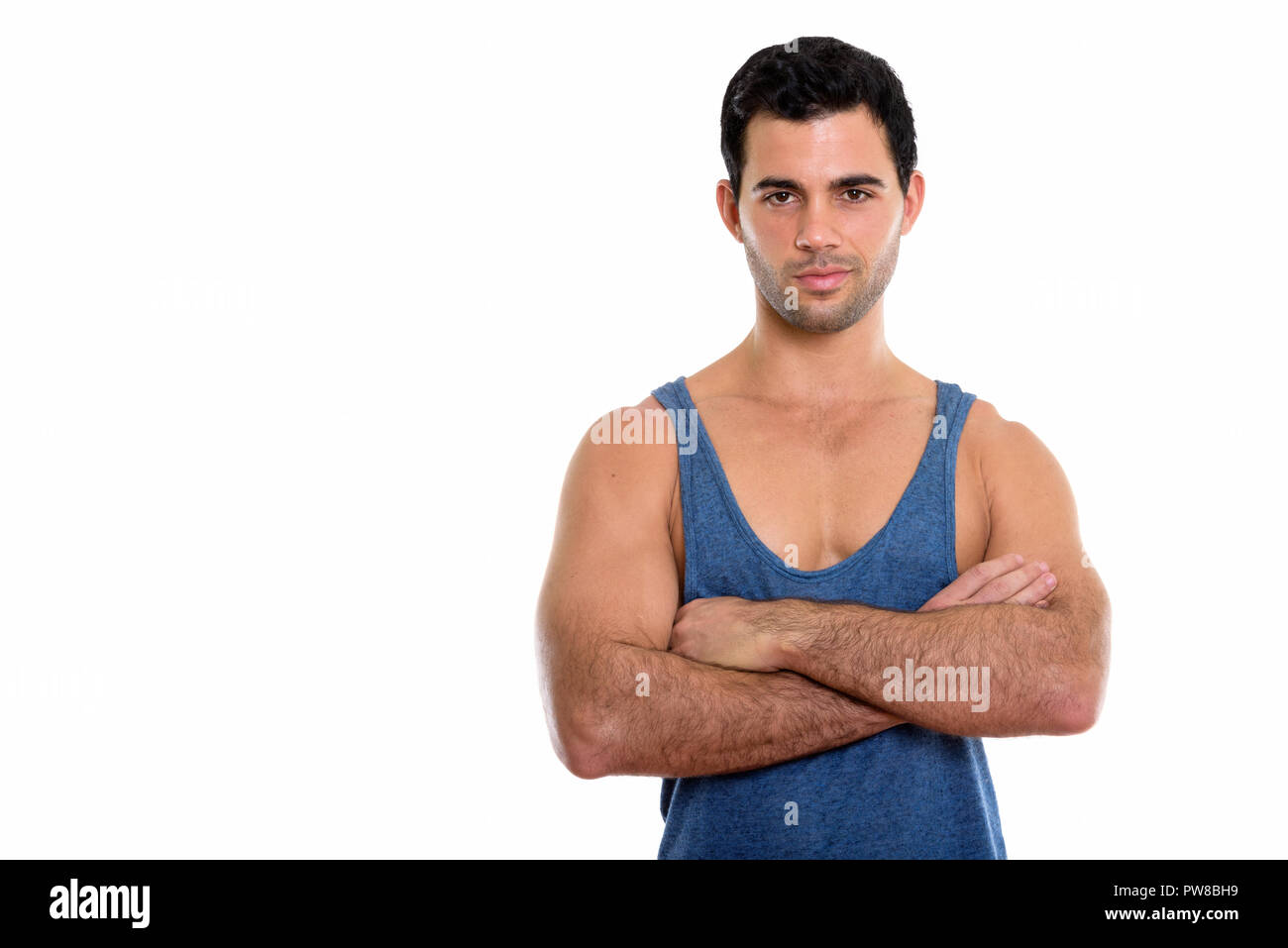 Studio shot of young handsome Hispanic man with arms crossed Stock ...