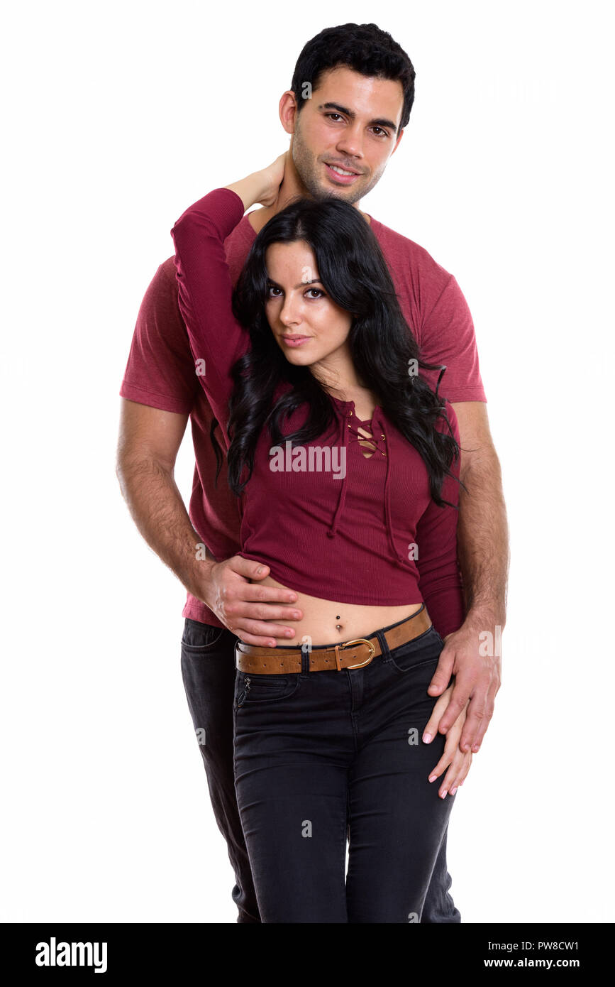 Studio shot of young happy couple smiling with woman posing agai Stock Photo