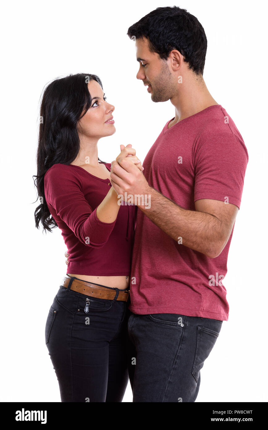 Studio shot of young happy couple smiling while dancing and look Stock Photo