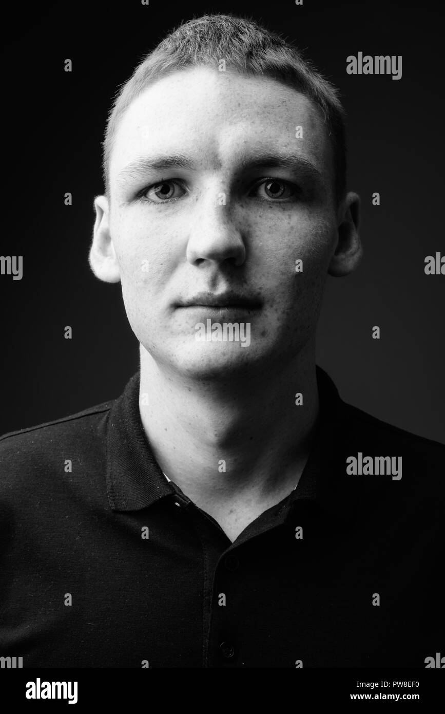 Young man against black background in black and white Stock Photo - Alamy