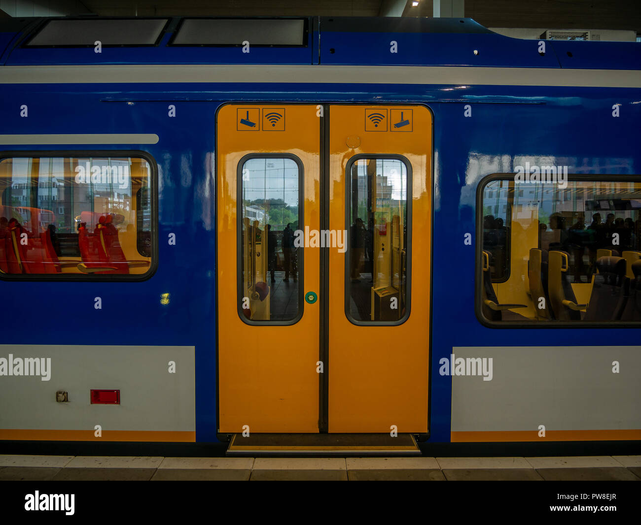 Breda, Netherlands - August 25, 2018 : Door of yellow train in railway station in the Netherlands. Stock Photo