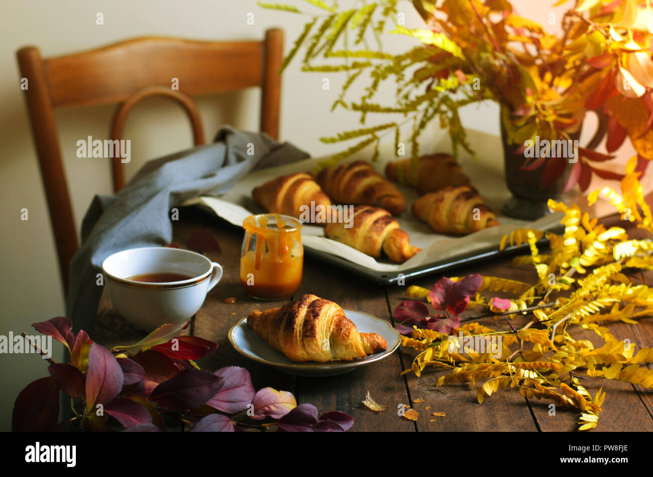 Cozy Autumn Still Life, Fall Breakfast, Freshly Baked Croissants with  Cinnamon and Salted Caramel, Cup of Tea and Autumn Leaves on Wooden Table  Stock Photo - Alamy, image size:1300x951