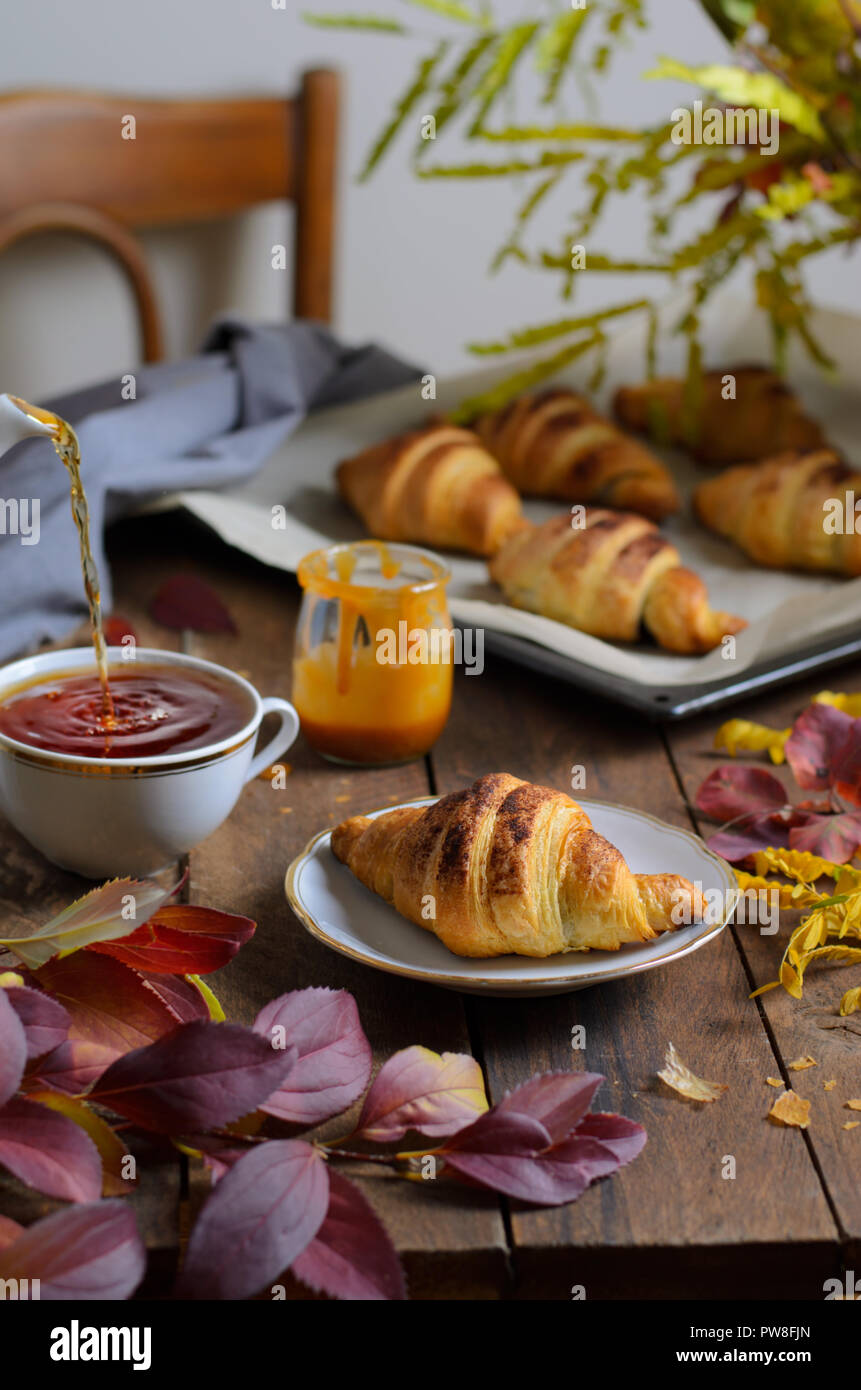 Cozy Autumn Still Life, Fall Breakfast, Freshly Baked Croissants with  Cinnamon and Salted Caramel, Cup of Tea and Autumn Leaves on Wooden Table  Stock Photo - Alamy, image size:861x1390
