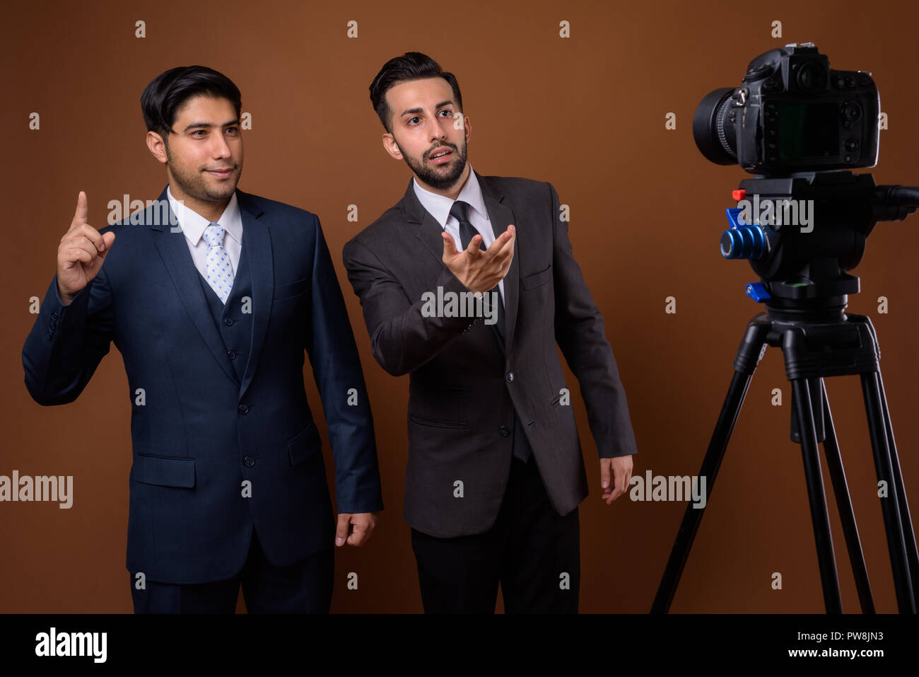 Studio shot of young handsome Iranian brothers together against  Stock Photo