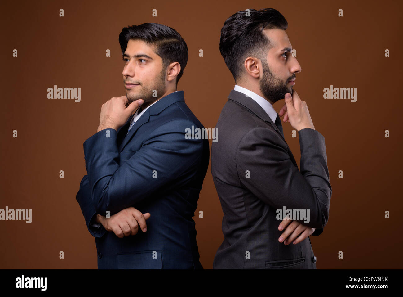 Studio shot of young handsome Iranian brothers together against  Stock Photo