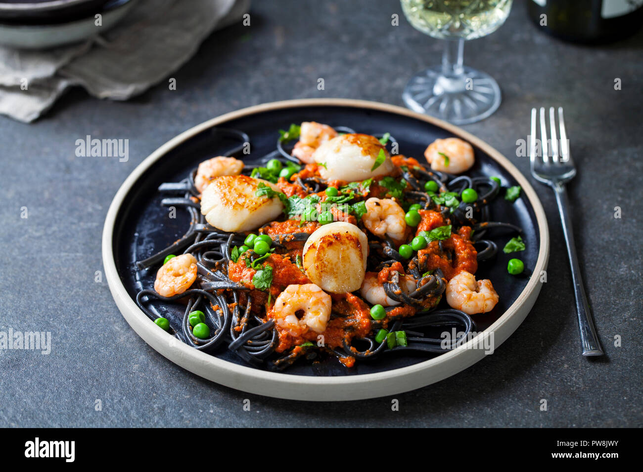 Squid ink pasta with prawns and scallops Stock Photo