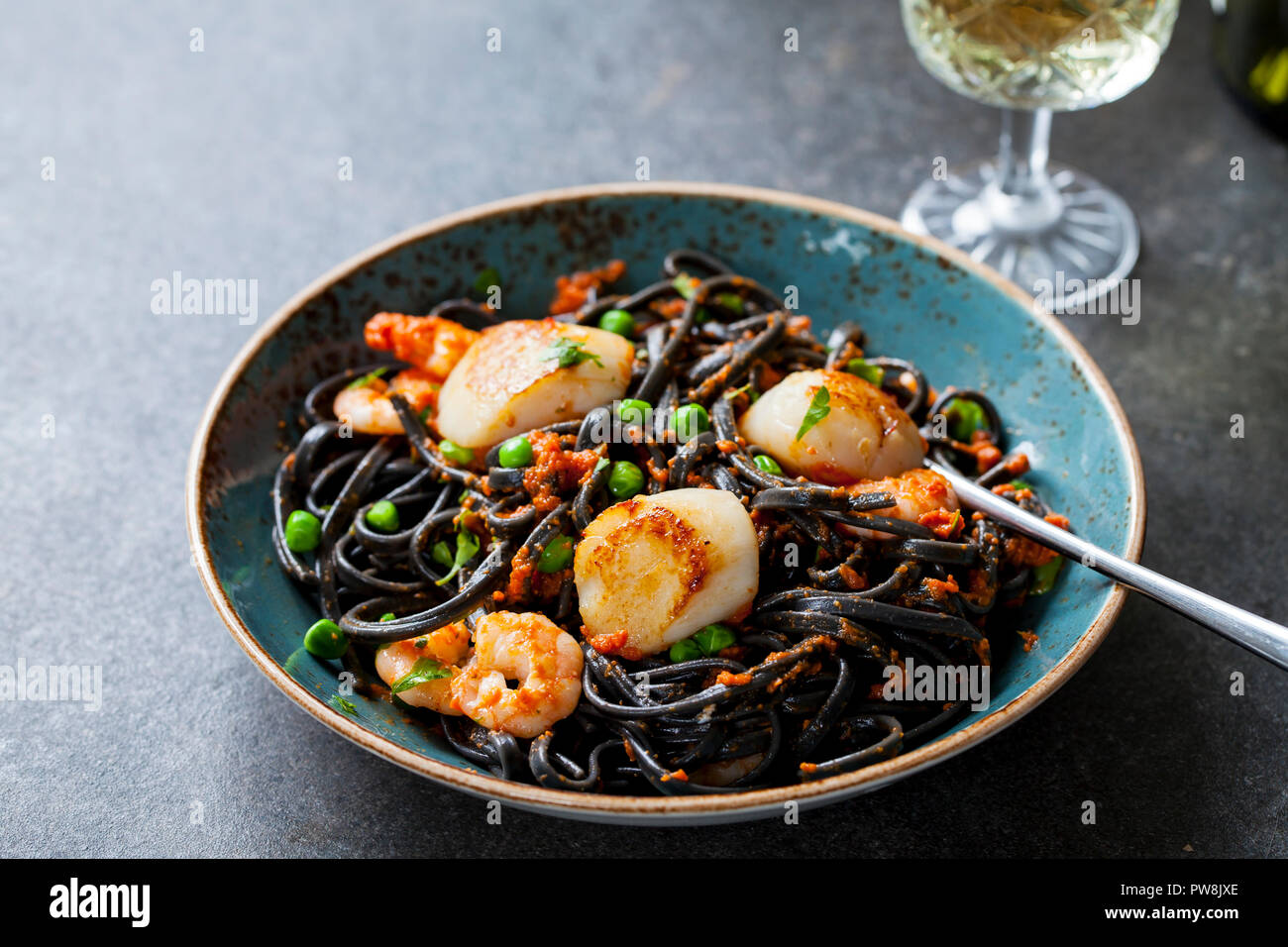 Squid ink pasta with prawns and scallops Stock Photo - Alamy