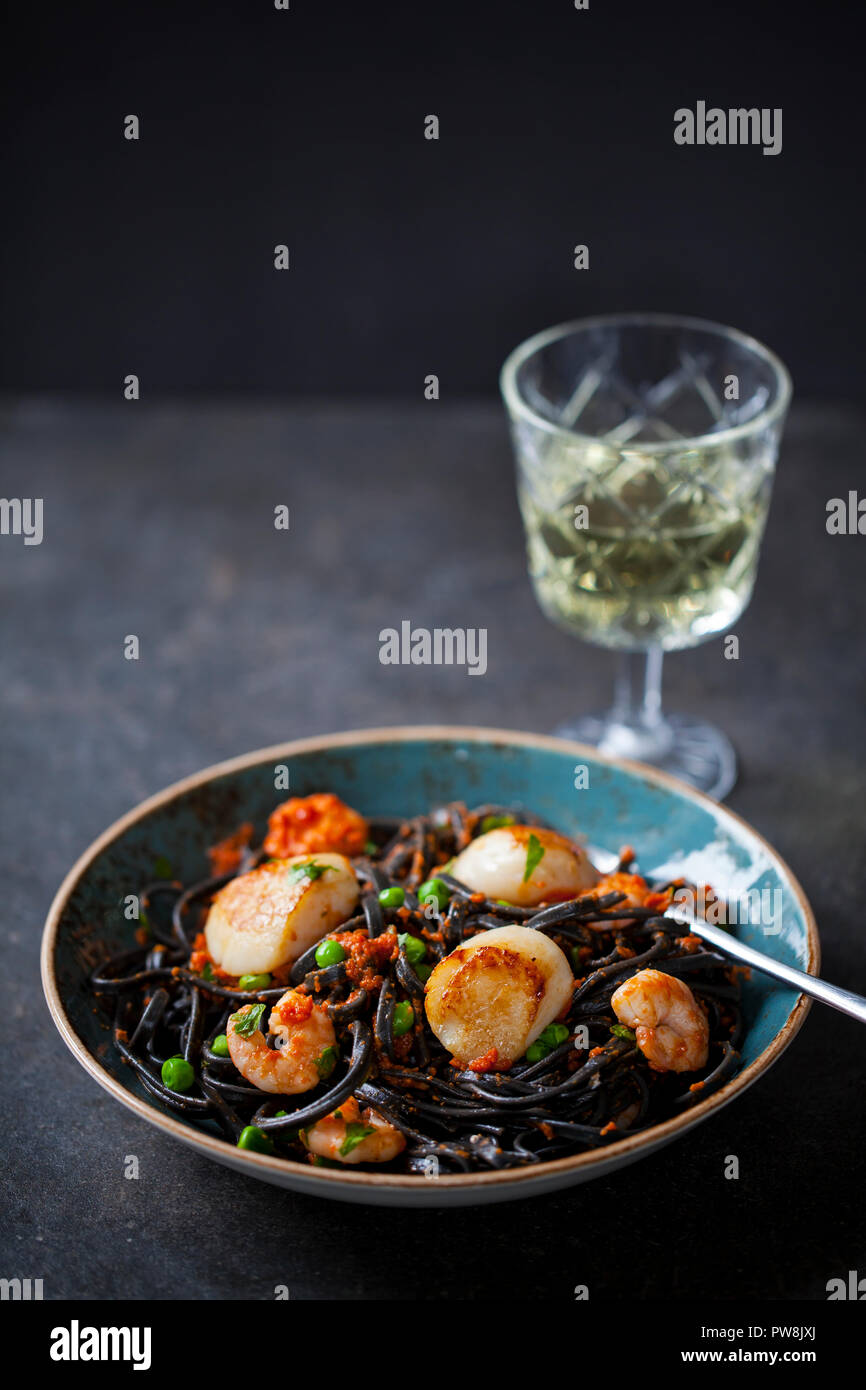 Squid ink pasta with prawns and scallops Stock Photo