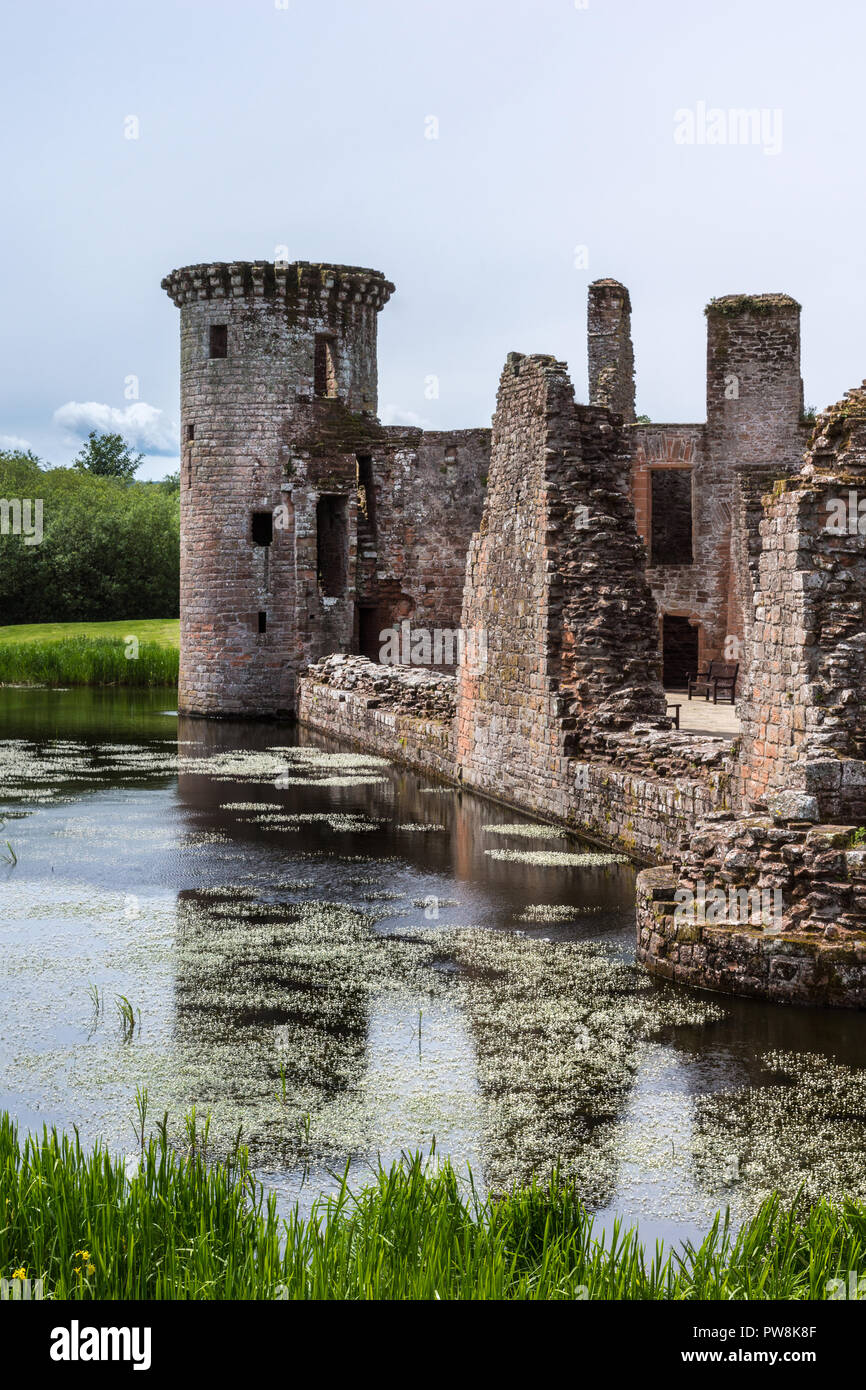 Shearington, Scotland, UK - June 18, 2012: Closeup of South side of ruined  triangular brown stone moated Caerlavarock Castle, while looking at tower. Stock Photo