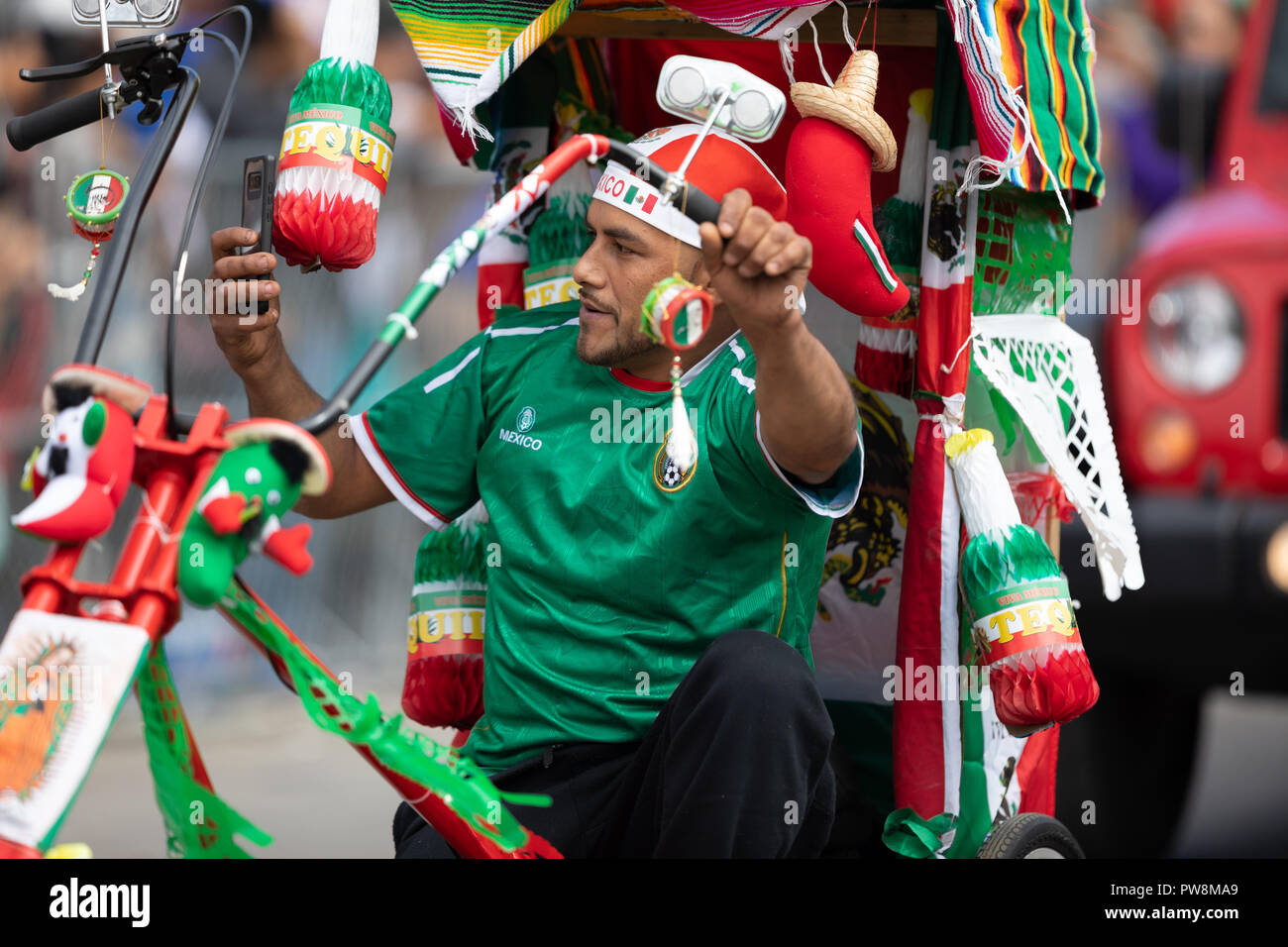 Chicago, Illinois , USA - September 9, 2018 The 26th Street Mexican Independence Parade, mexican man riding a bicycle with many representations of the Stock Photo