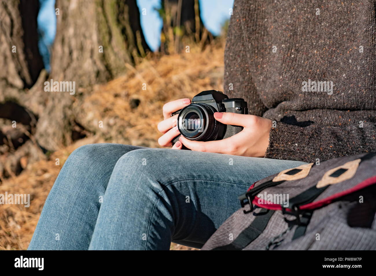 Vintage film camera in female hands. Close up shot of a woman holding film camera outdoors Stock Photo