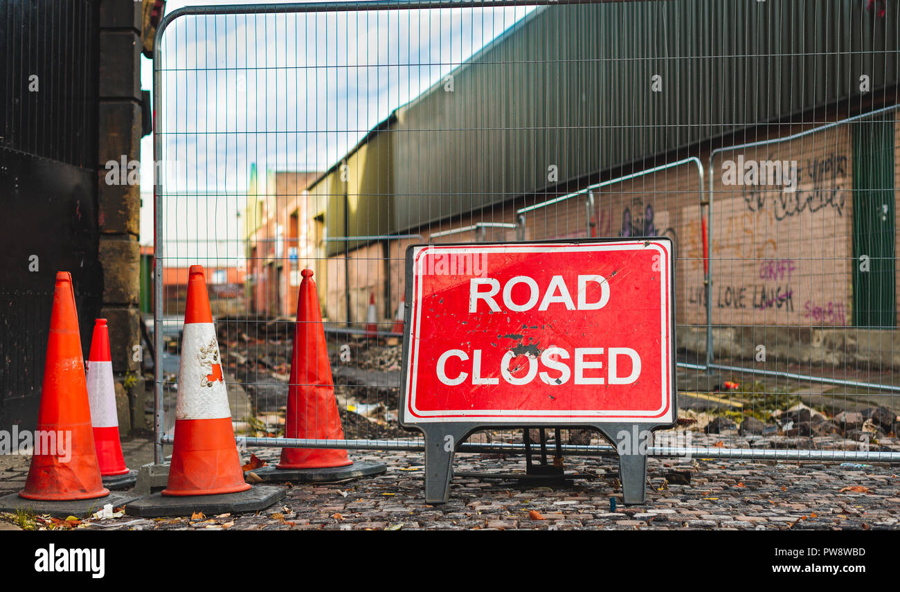 A road closed sign and bollards stop cars from using a road in Sheffield, UK Stock Photo