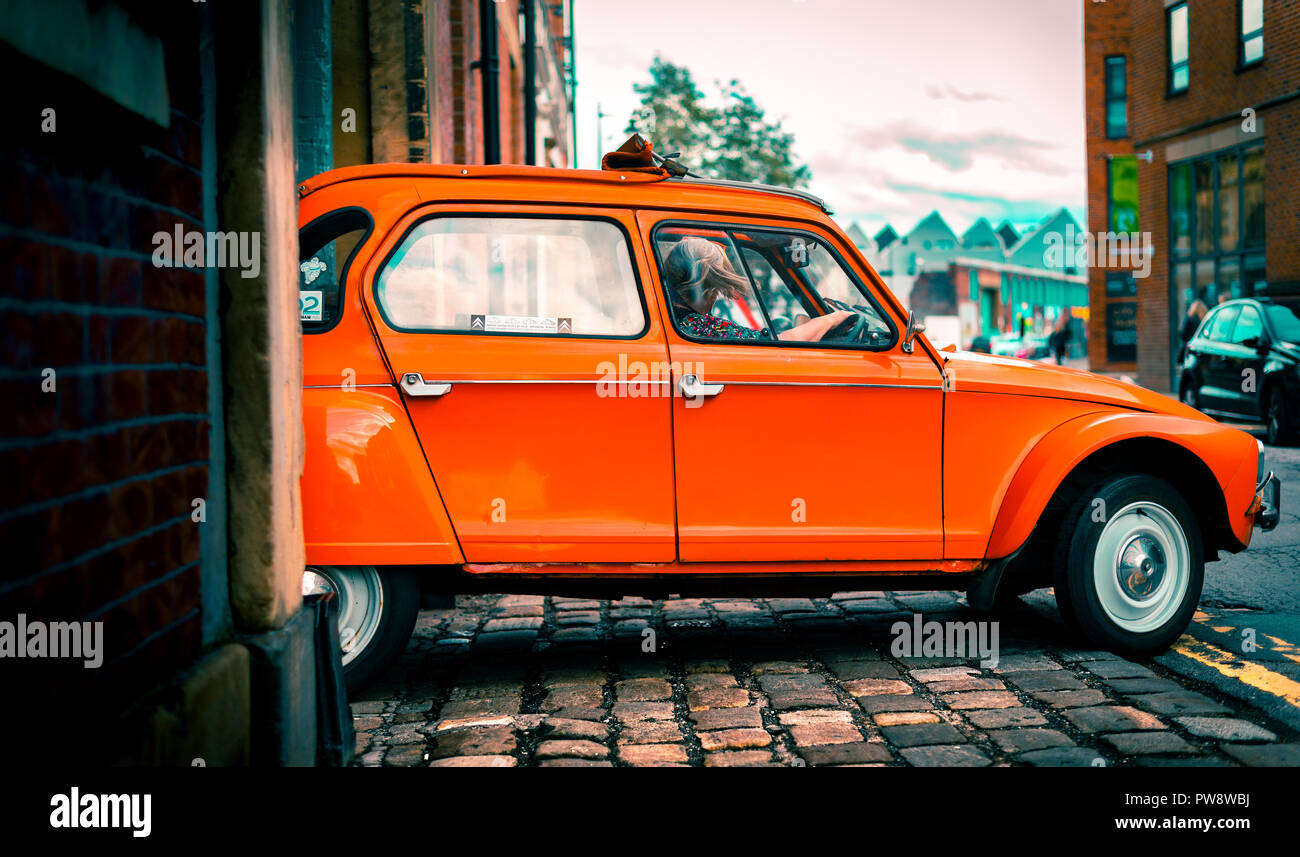 A Citroën Dyane leaves a parking garage driven by an old woman in Sheffield, UK Stock Photo