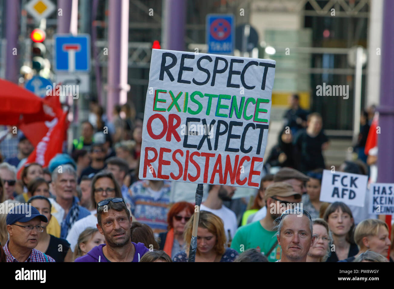 Frankfurt, Germany. 13th October 2018. A protester holds a poster that reads 'Respect existence or expect resistance'. Over 3,500 people marched through Frankfurt, to protest against  racism and for tolerance. They where accompanied by many local bands, performing on the way and at the rallies. The protest was part of several other protests against racism in Germany on the same day. Credit: Michael Debets/Alamy Live News Stock Photo
