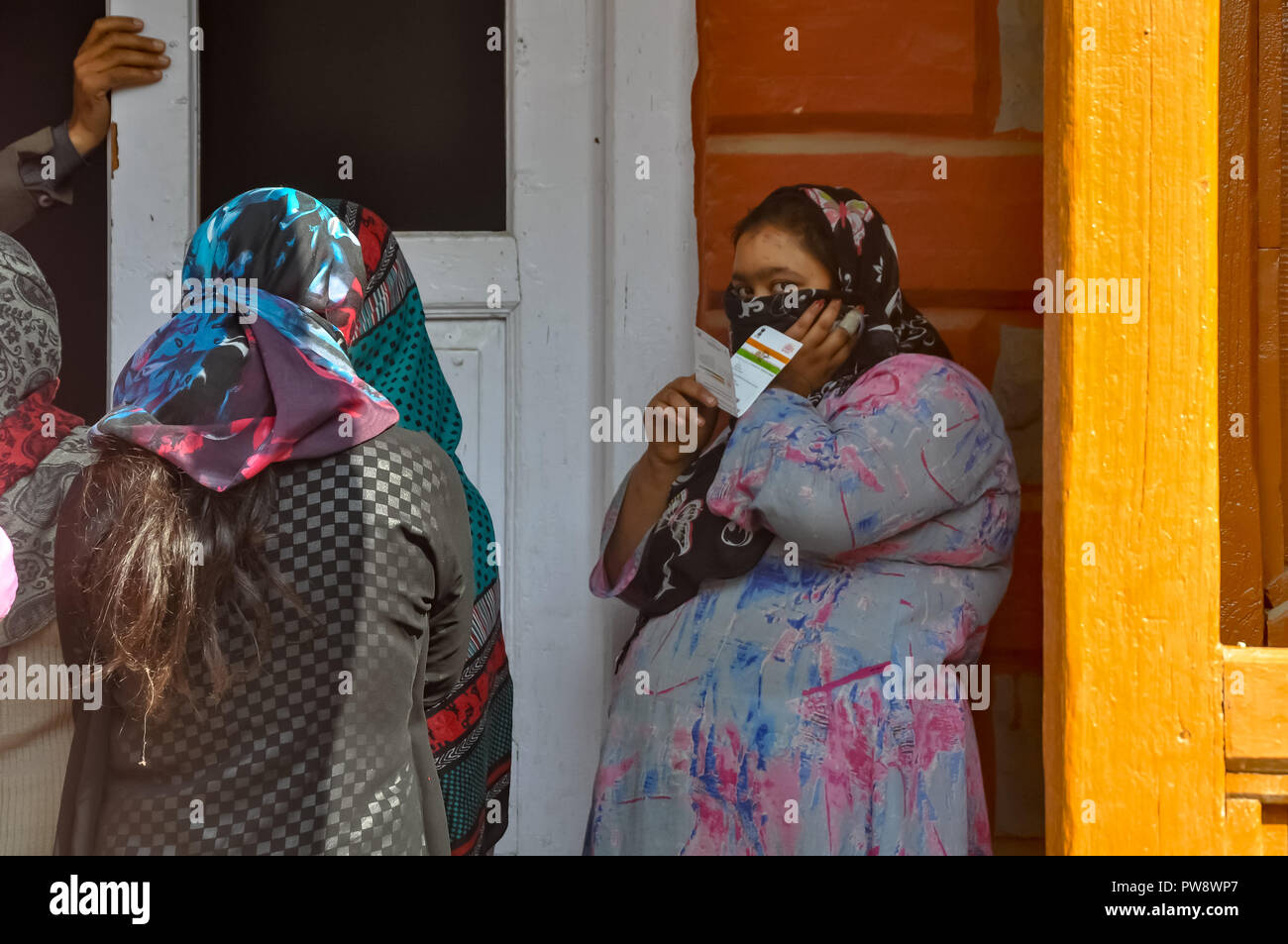 October 13, 2018 - Srinagar, Jammu & Kashmir, India - Kashmiri women are seen hiding their faces as they stands outside waiting to caste their ballots during the third phase of local elections.A Complete Strike was observed in poll bound areas of Srinagar where they recorded the lowest voter turnout with less than three per cent electorates exercising their franchise during the ongoing municipal polls. Credit: Idrees Abbas/SOPA Images/ZUMA Wire/Alamy Live News Stock Photo