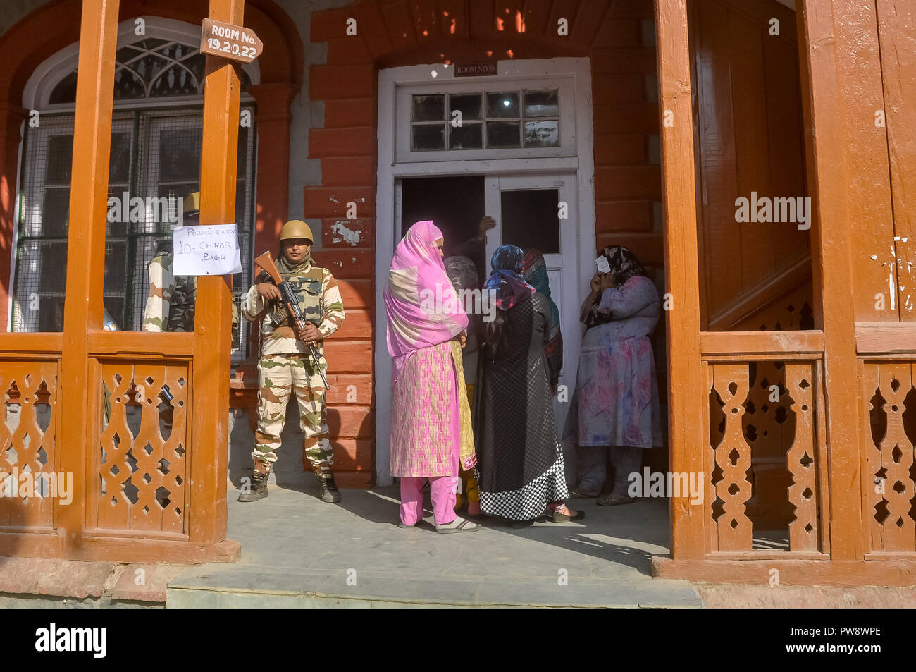 October 13, 2018 - Srinagar, Jammu & Kashmir, India - Kashmiri women are seen hiding their faces as they stands outside waiting to caste their ballots during the third phase of local elections.A Complete Strike was observed in poll bound areas of Srinagar where they recorded the lowest voter turnout with less than three per cent electorates exercising their franchise during the ongoing municipal polls. Credit: Idrees Abbas/SOPA Images/ZUMA Wire/Alamy Live News Stock Photo