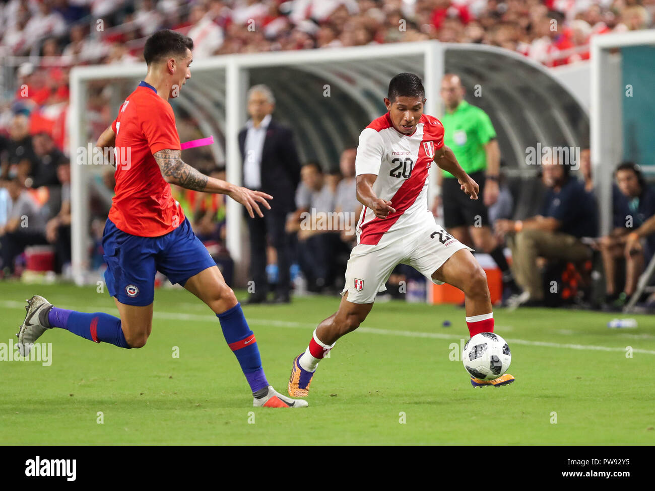 Miami Gardens, Florida, USA. 12th Oct, 2018. Peru midfielder EDISON FLORES (20) drives the ball, challenged by Chile defender ENZO ROCO (3), during an international friendly match between the Peru and Chile national soccer teams, at the Hard Rock Stadium in Miami Gardens, Florida. Credit: Mario Houben/ZUMA Wire/Alamy Live News Stock Photo