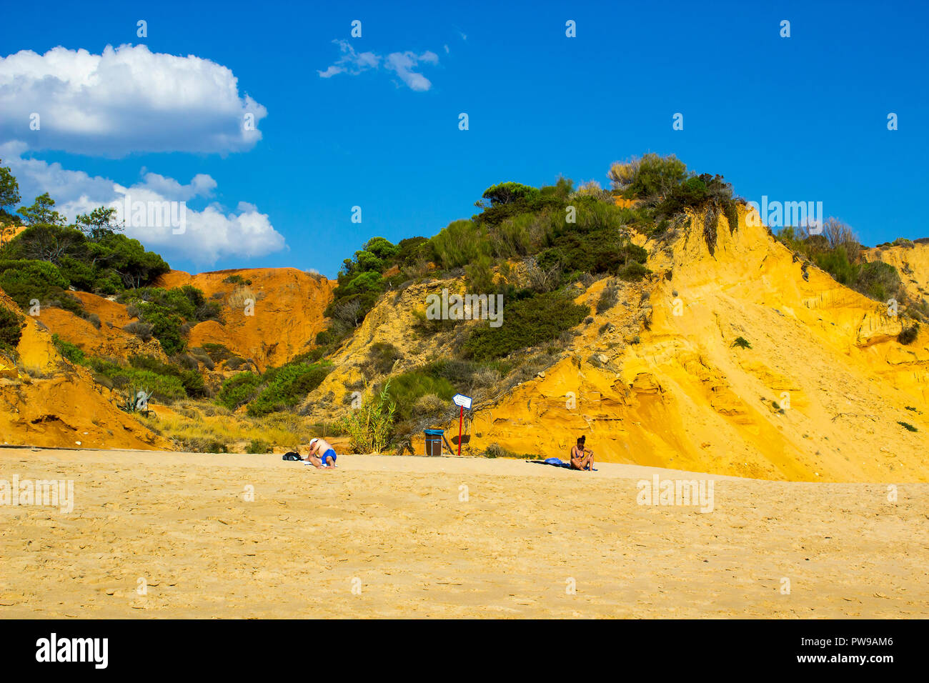 29 September 2018 A couple relax and sunbath on a remote part of the Oura Praia beach in Albferiah on the Algarve in Portugal Stock Photo