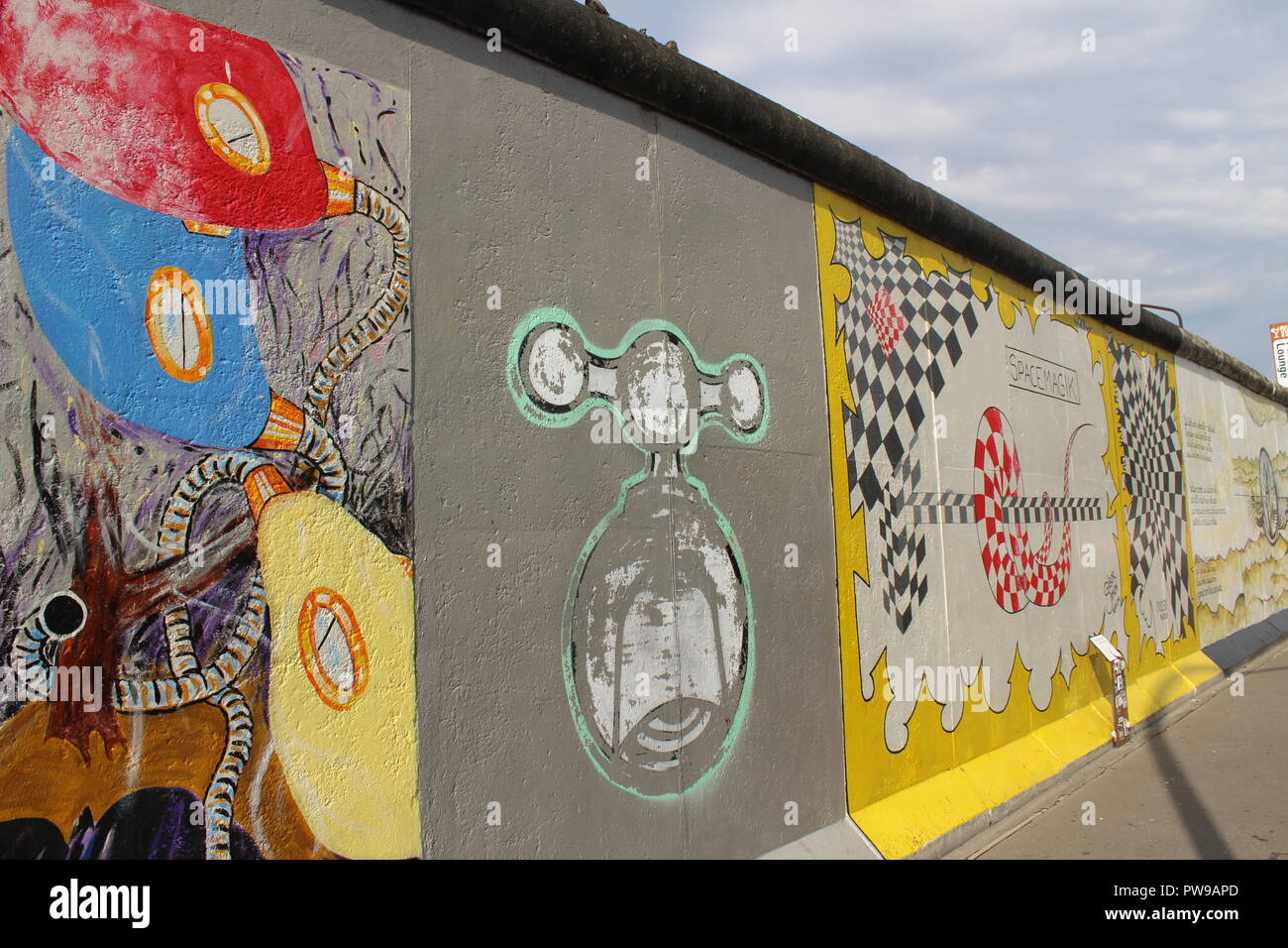 East Side Gallery - Berlin Wall - The Section where Jens-Helge Dahmen's Pneumo meets Gábor Simon's - Space Magik with graffiti in between Stock Photo - Alamy