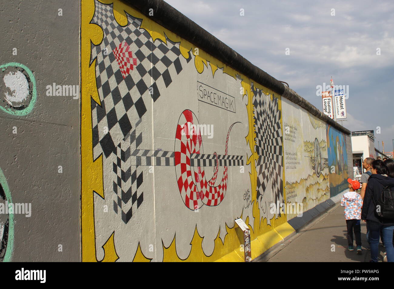 Tourists Looking at Space Magik by Gabor - East Side Gallery, Berlin Wall, Germany Stock Photo - Alamy