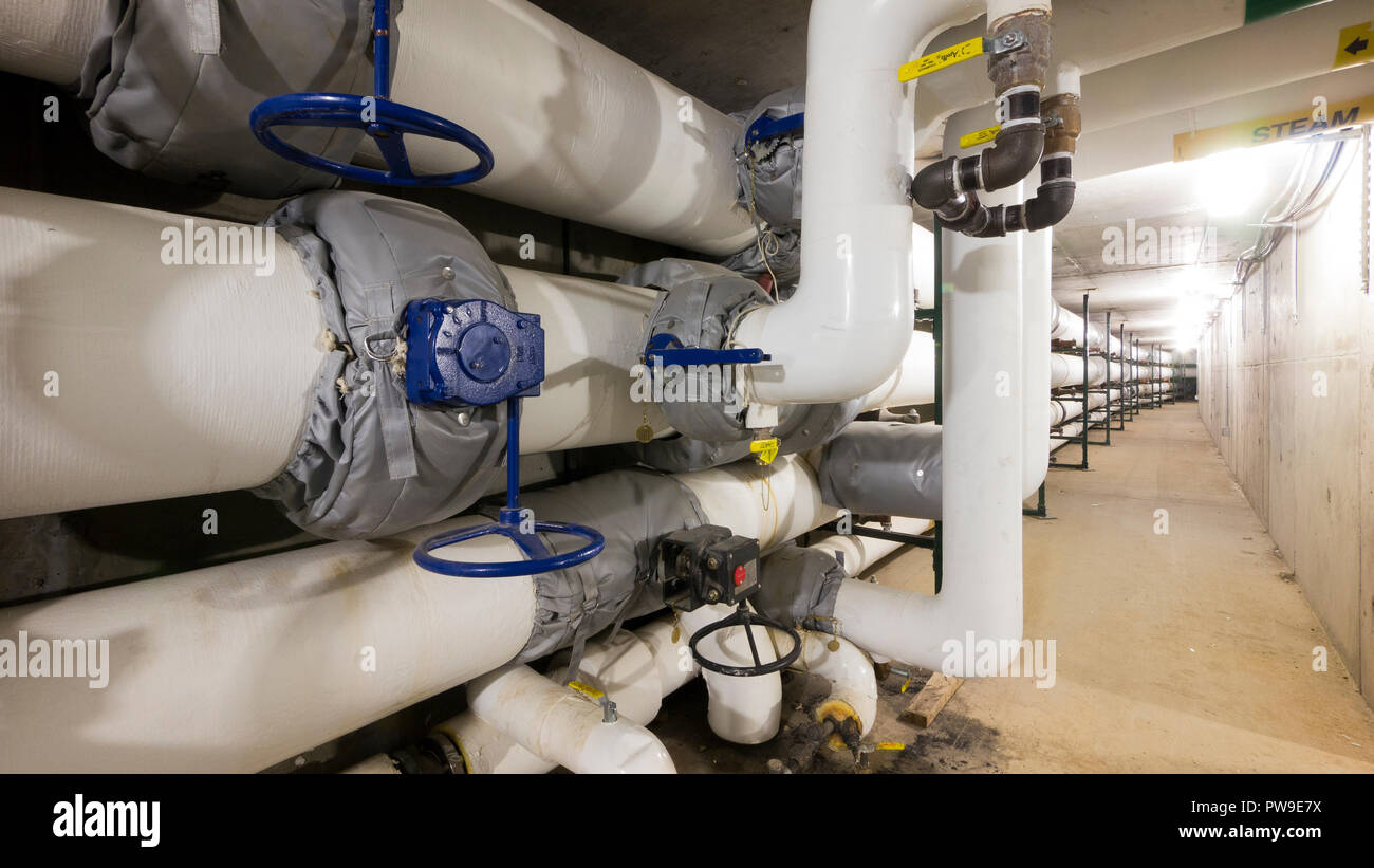 Heavily insulated steam and water pipes in a commercial facility Stock Photo