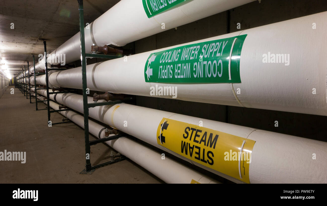 Heavily insulated steam and water pipes in a commercial facility Stock Photo