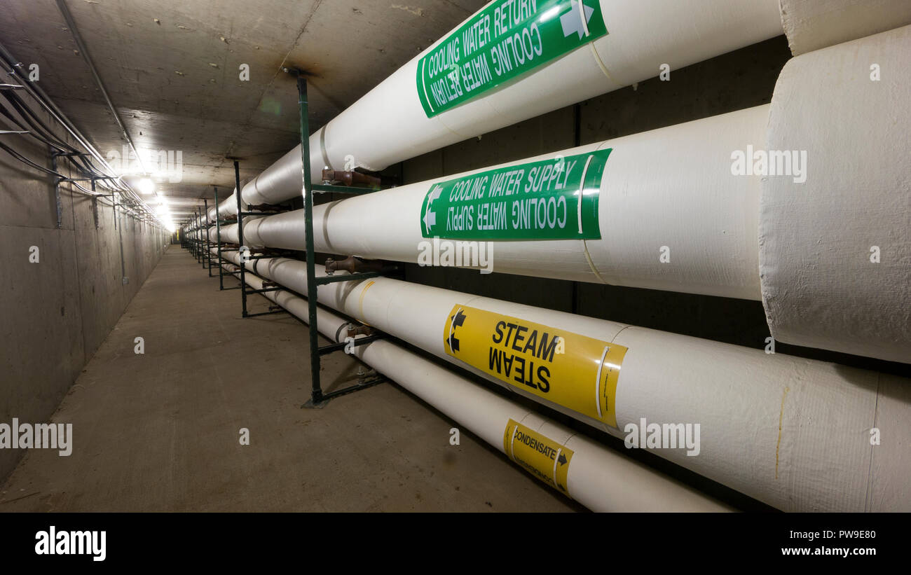 Heavily insulated steam and water pipes in a commercial facility Stock Photo