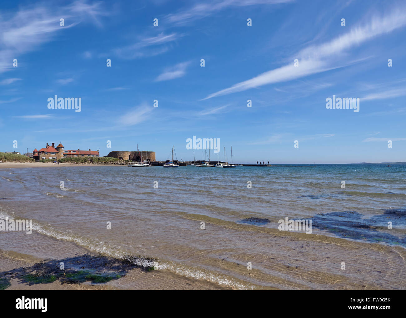 A Landscape photo of Beadnell Bay and Beach looking towards the Harbour and Old Lime Kilns in Northumberland, England, UK. Stock Photo