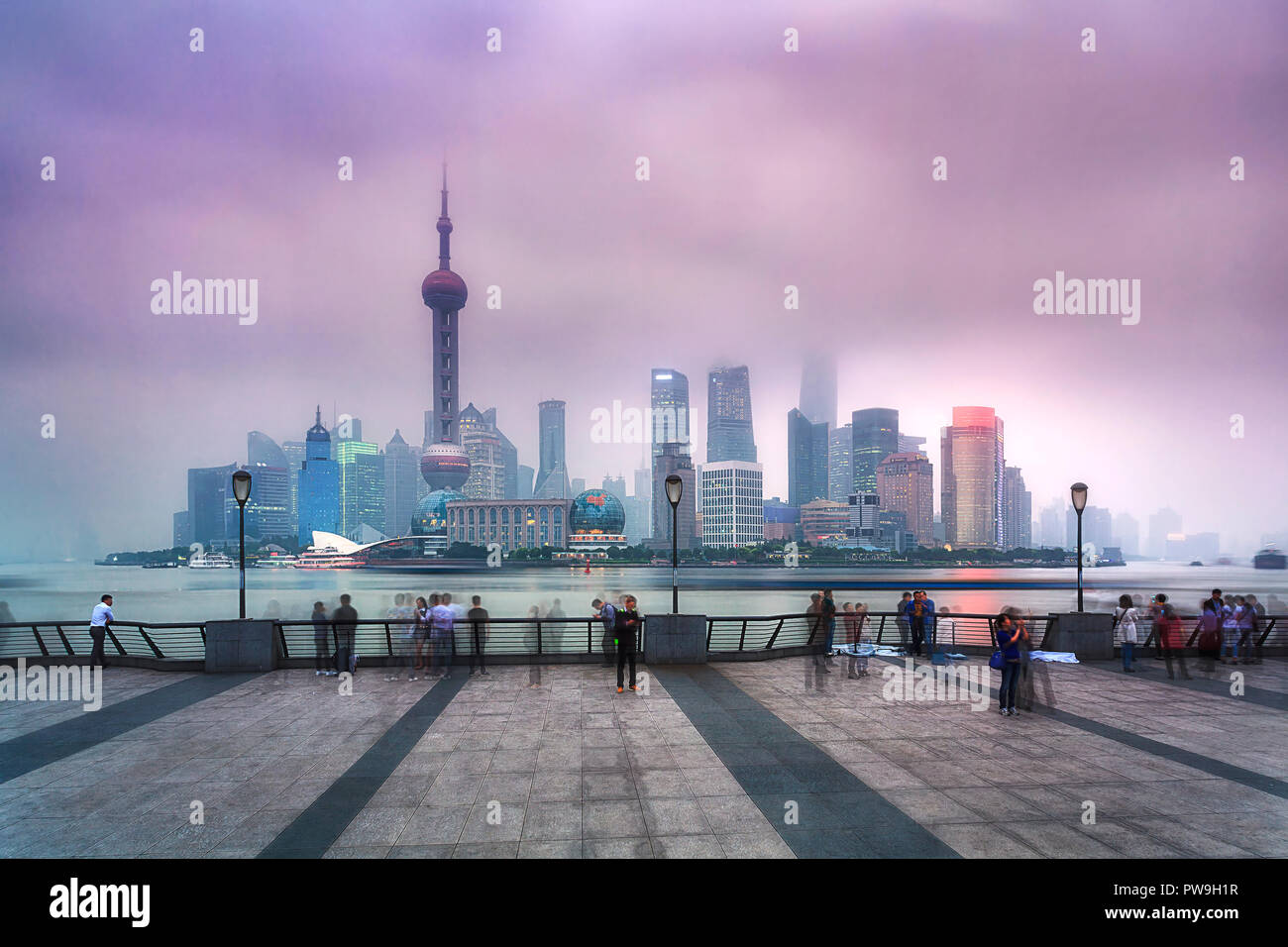 China SHanghai Pudong CBD sunset view over river illuminated skyscrapers and towers covered by pollution smog Stock Photo