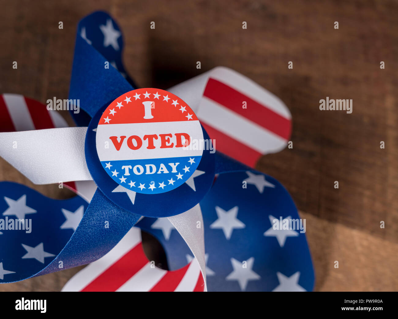 I Voted Today paper sticker on US Flag whirligig and rural wooden table Stock Photo