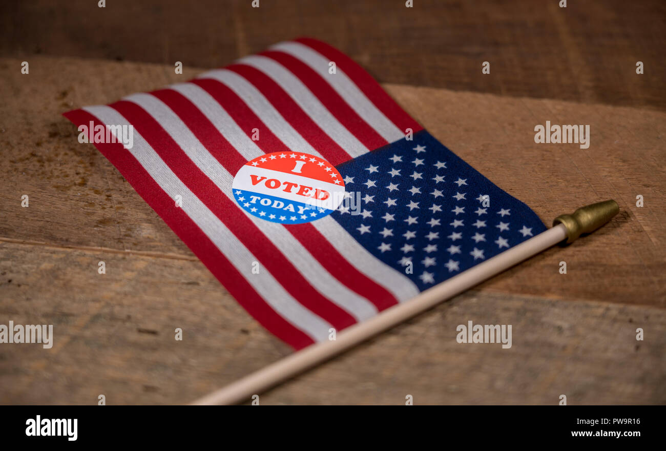 Narrow focus on I Voted Today paper sticker on US Flag  Stock Photo