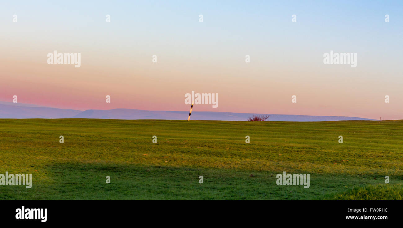 Golf course with striped pin and hills in the distance. Werneth Low, Manchester, UK Stock Photo