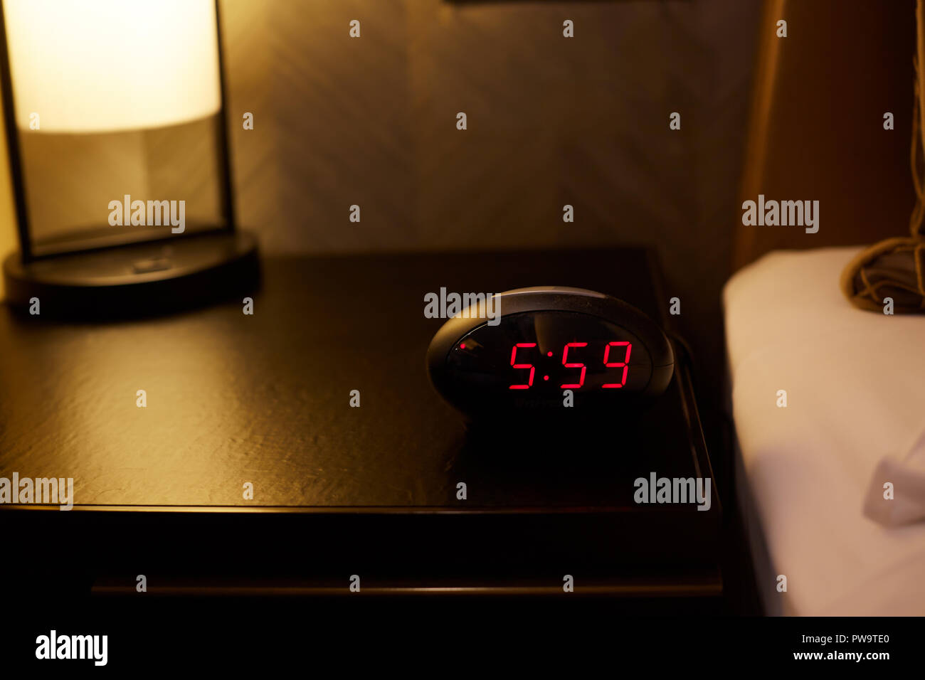 Alarm clock work time on the bed 05:59 am. Stock Photo