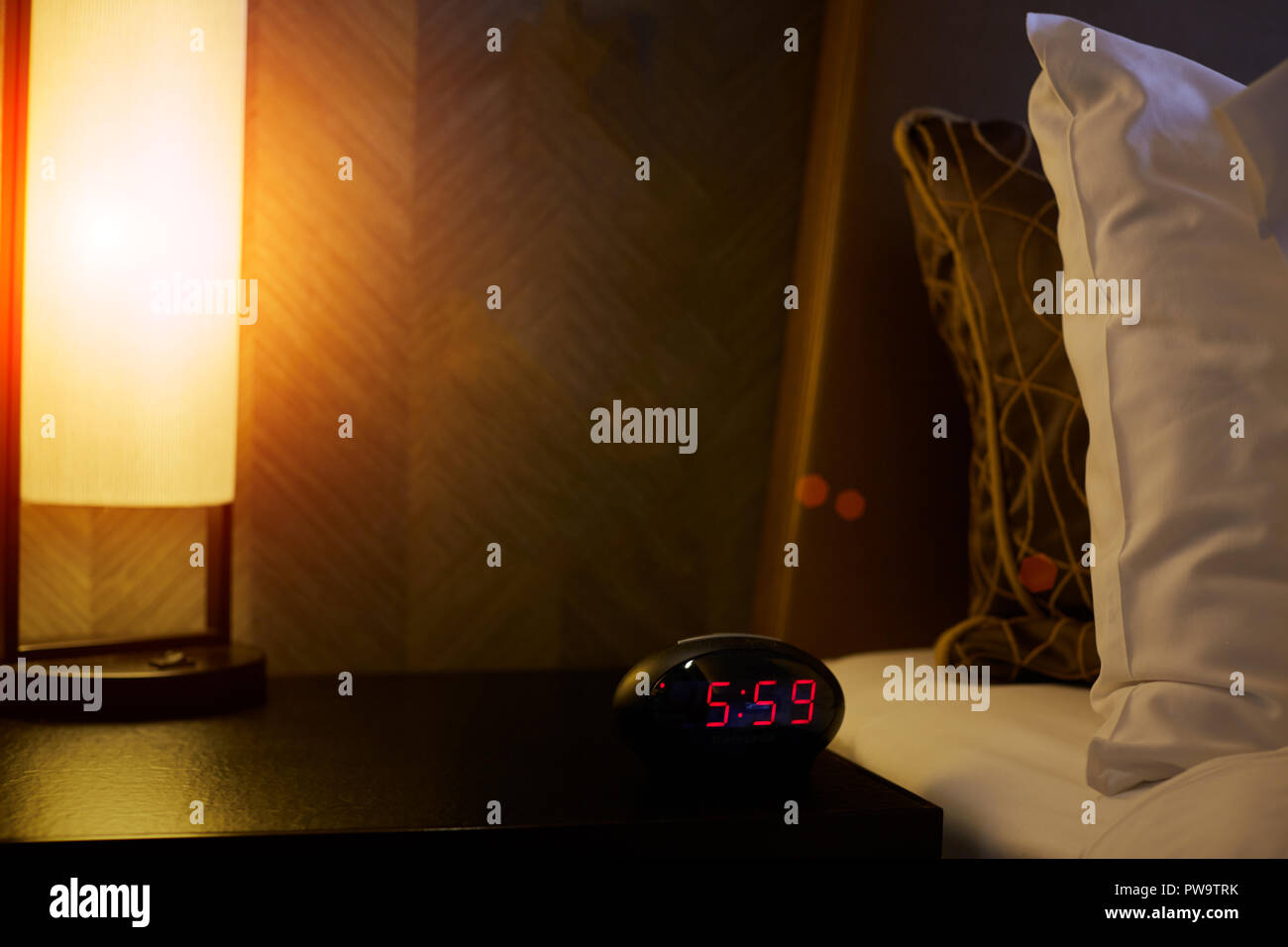 Alarm clock near the bed in bedroom Stock Photo