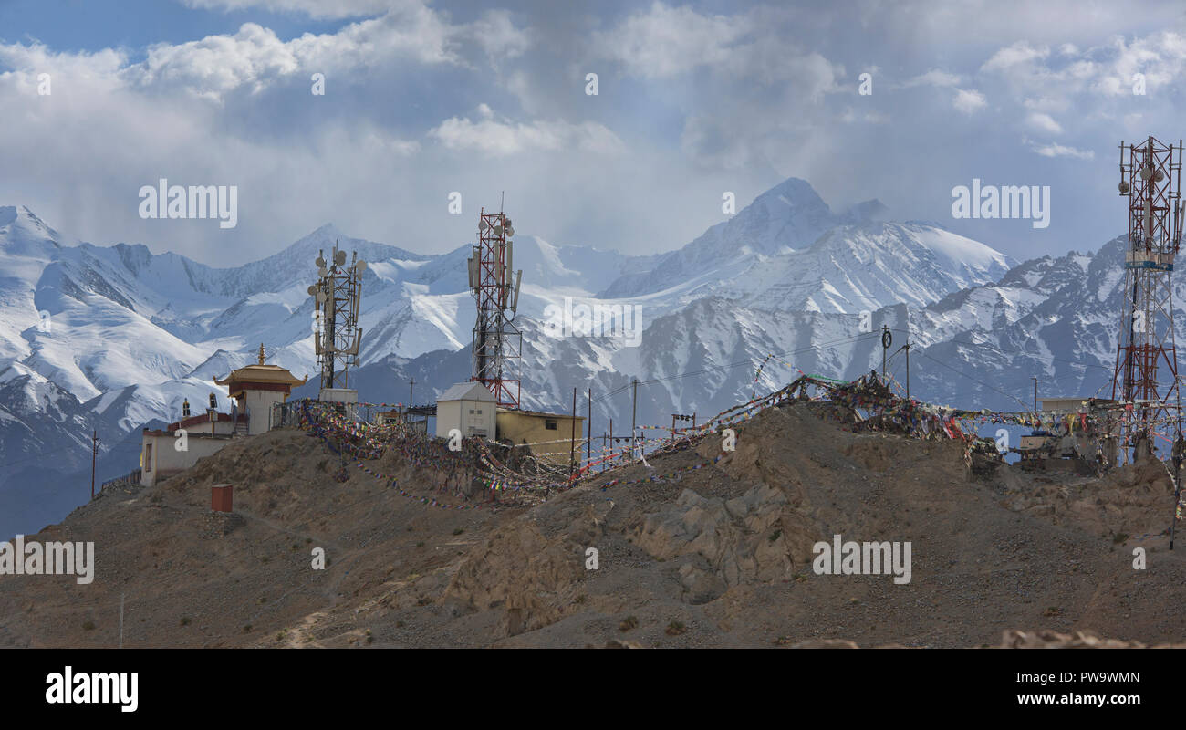 The Stok Range above prayer flag-draped telephone towers, Leh, Ladakh, India Stock Photo