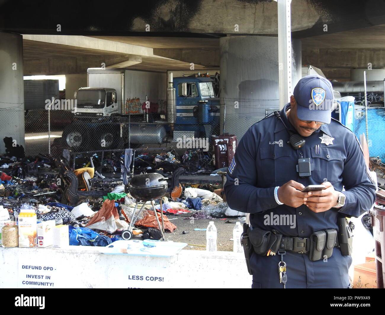 Oakland police Sgt. Anwawn Jones stands outside a homeless camp under the I-580 overpass on Peralta Street on May 2, 2017, the morning after the camp burned in a fire. Stock Photo