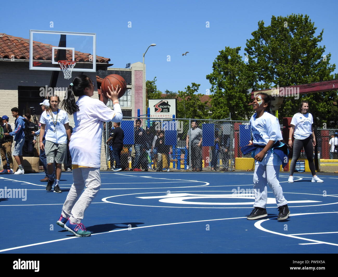 Two girls run passing drills on a basketball court in Lincoln Square Park in Oakland California, on May 17, 2017, just after the courts were built by the Kevin Durant Charity Foundation. Stock Photo