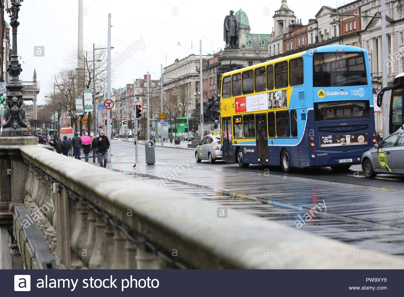 People and buses on O'Connell Bridge in Dublin, Ireland, on a rainy day in April Stock Photo