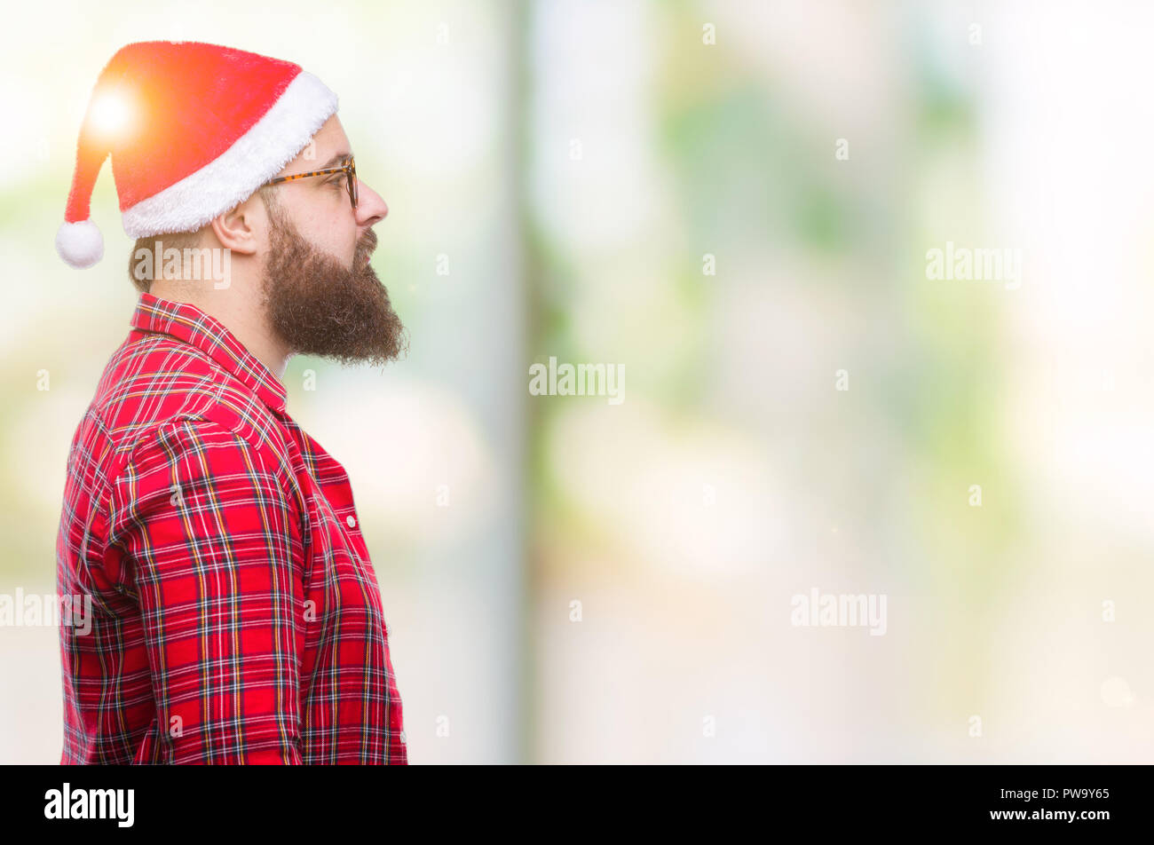Young caucasian man wearing christmas hat over isolated background ...