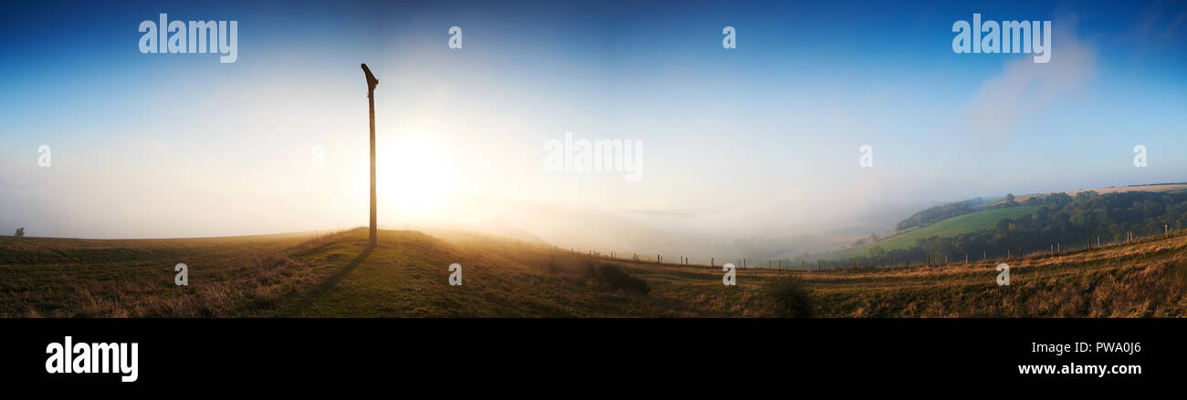 taken at Combe Gibbet, a Panorama at sunrise with fog surrounding the gibbet and sun shining through. Stock Photo