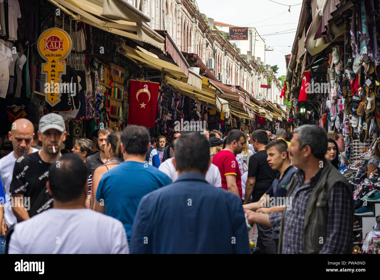 People walking down a narrow cobbled street past small shops, Istanbul, Turkey Stock Photo
