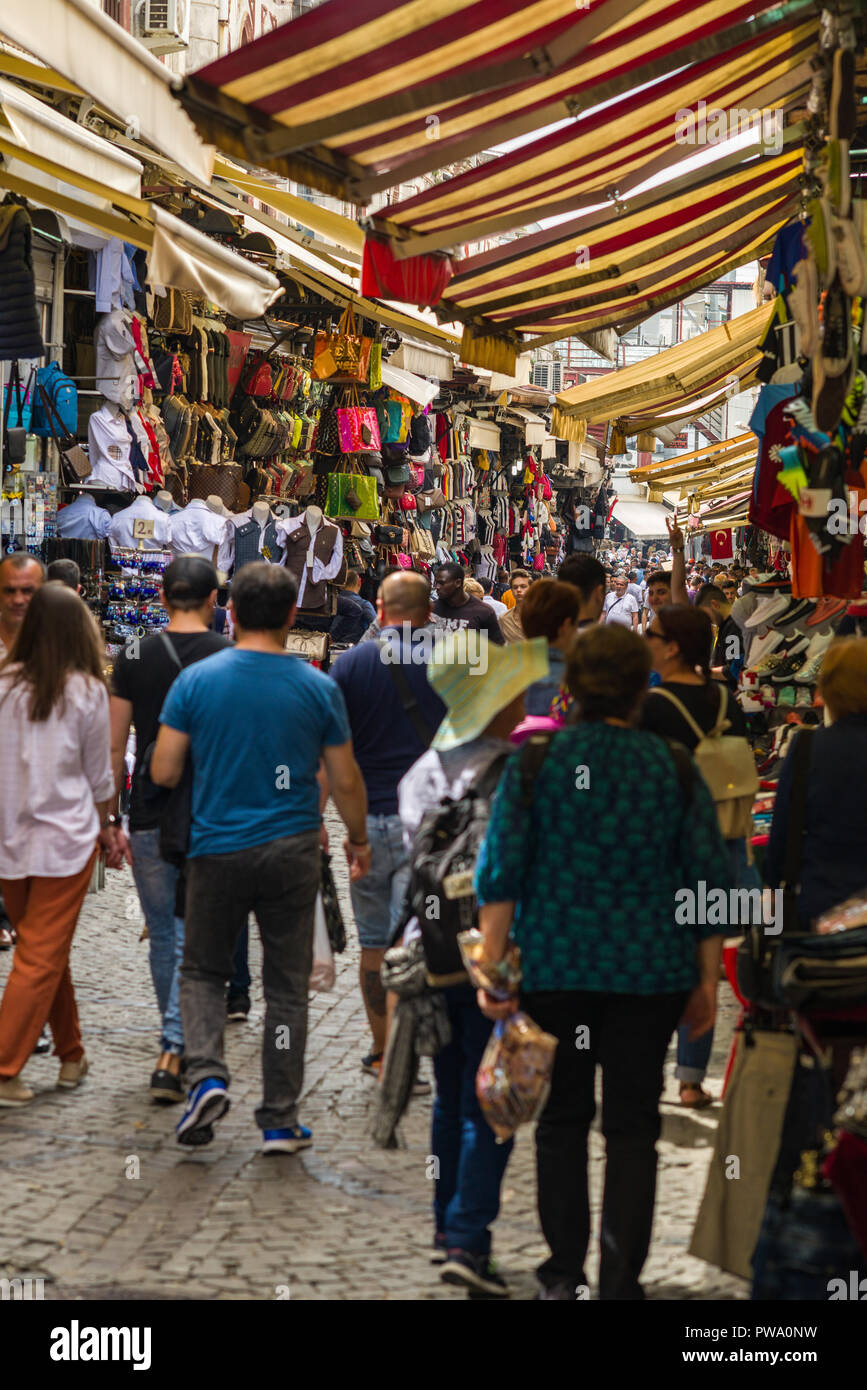 People walking down a narrow cobbled street past small shops, Istanbul, Turkey Stock Photo
