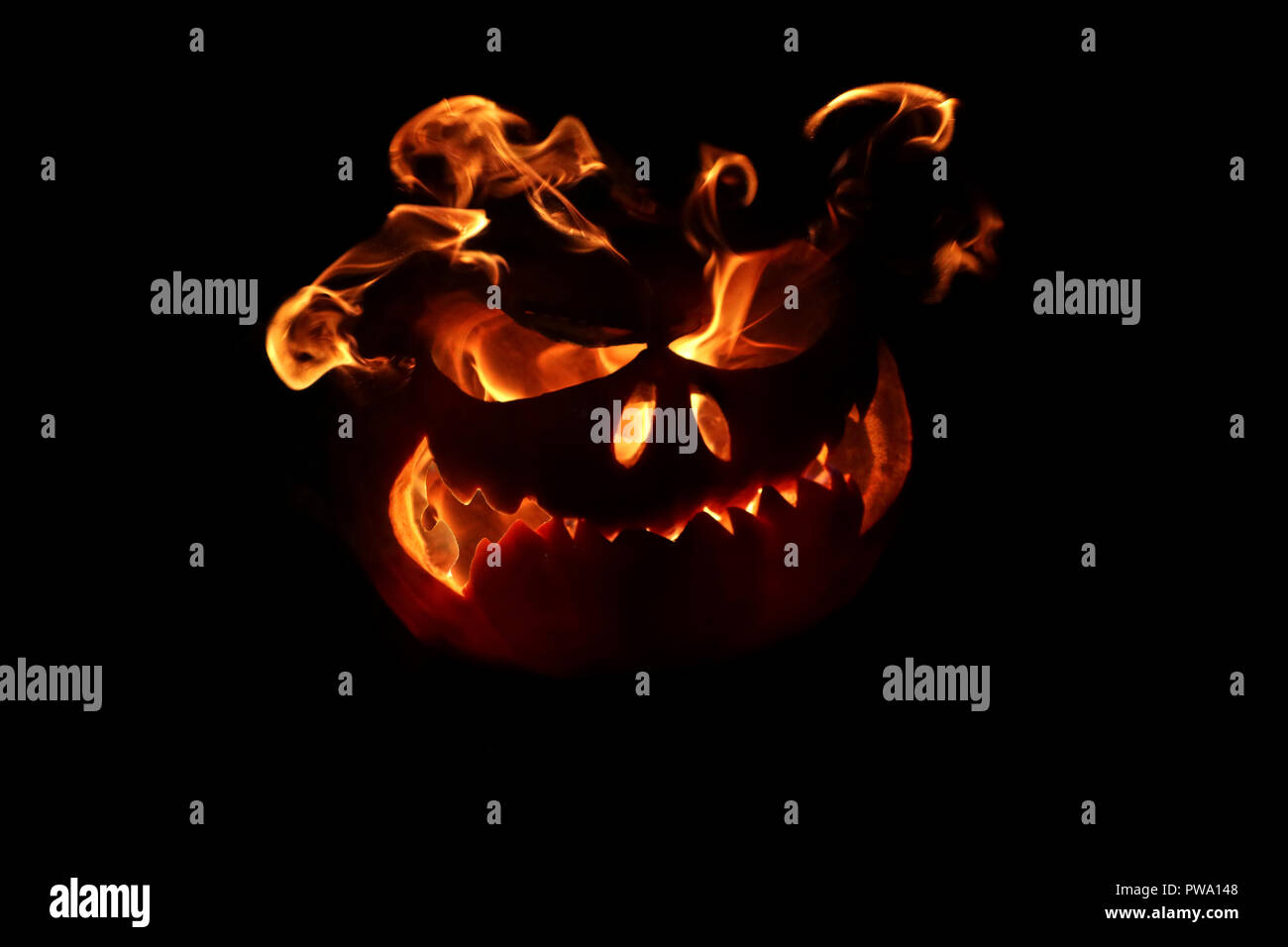 halloween pumpkin with flames from eyes on dark background Stock Photo