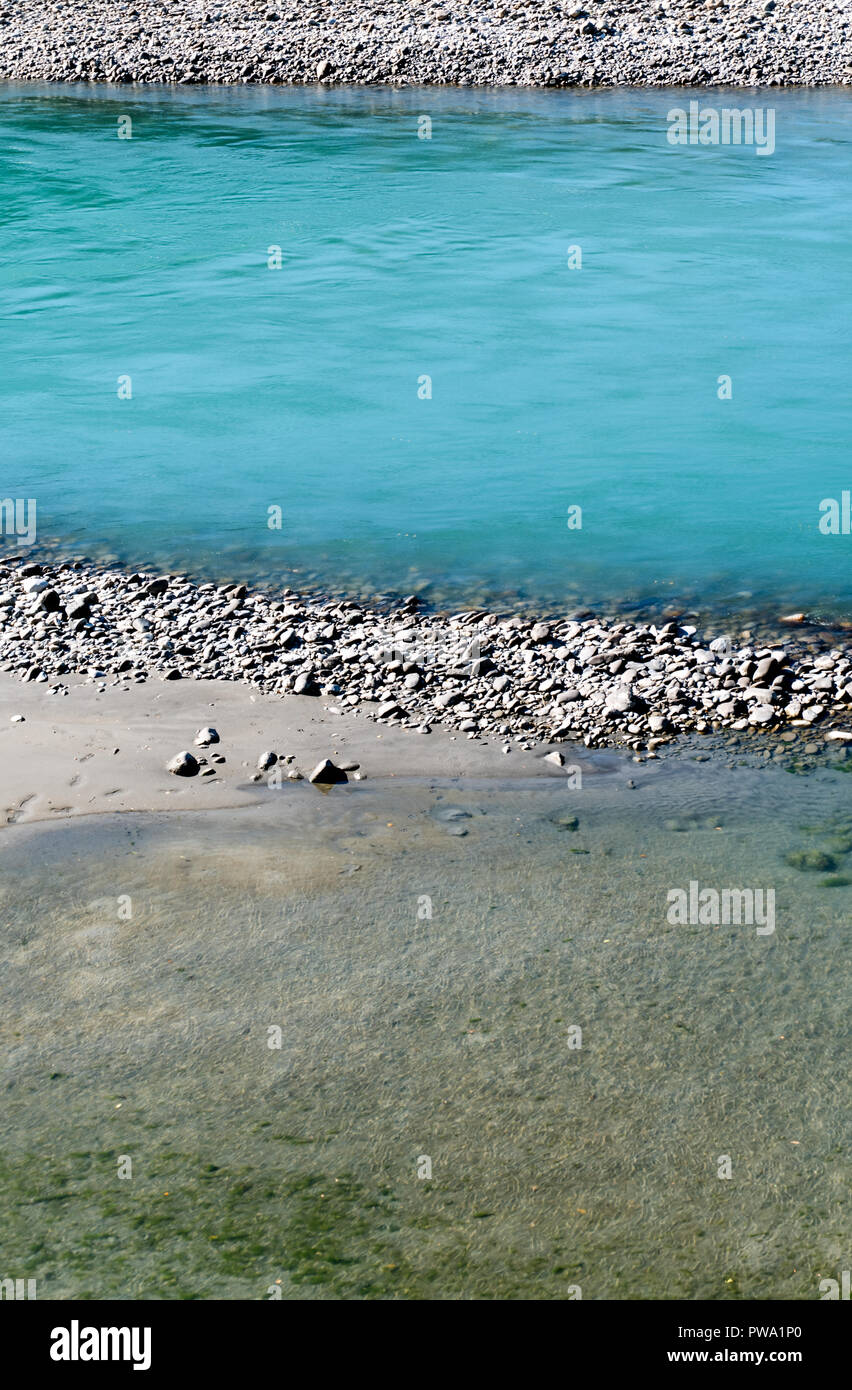 Rhine river with rocks and different color blue water in Switzerland near Maienfeld Stock Photo